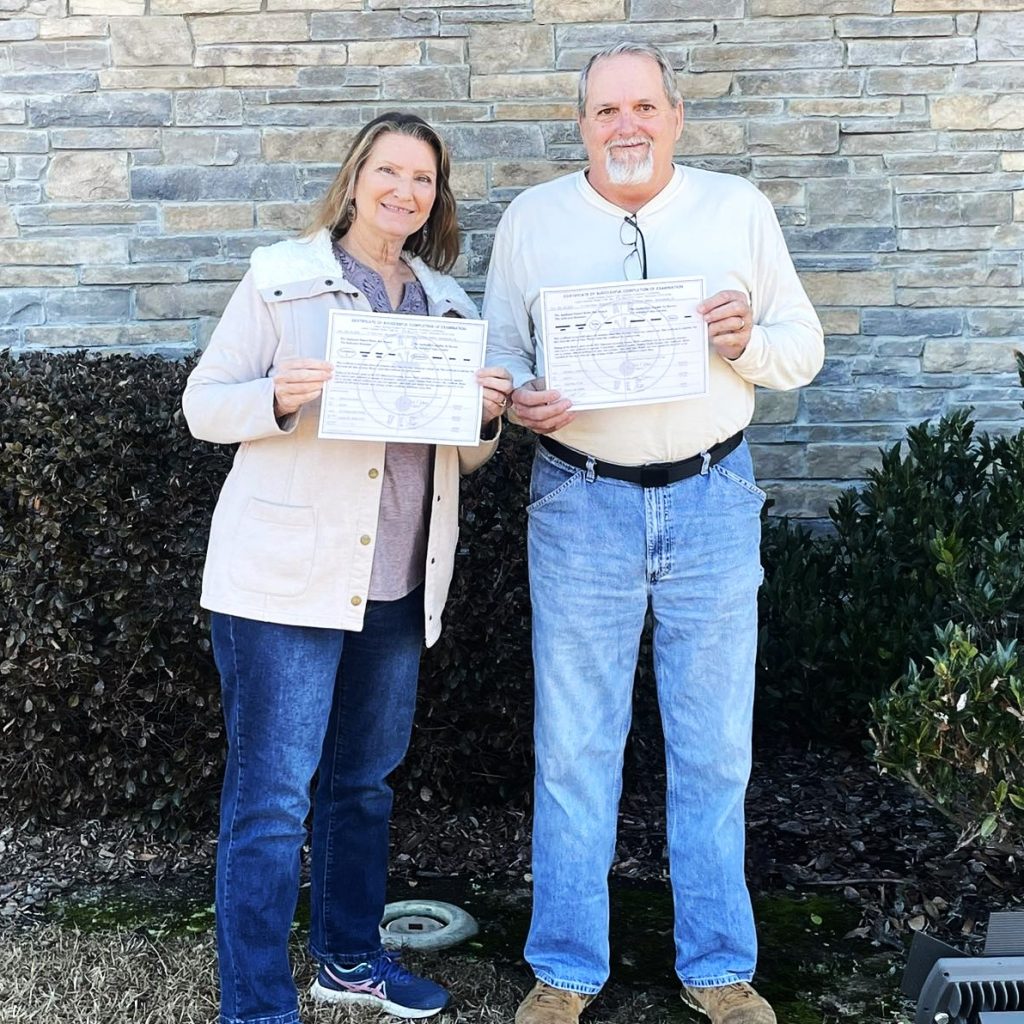 Jeff and Deborah Isenhour holding their certificates of successful completion of their exams after Jeff upgraded to Extra and Deborah earned her Technician.